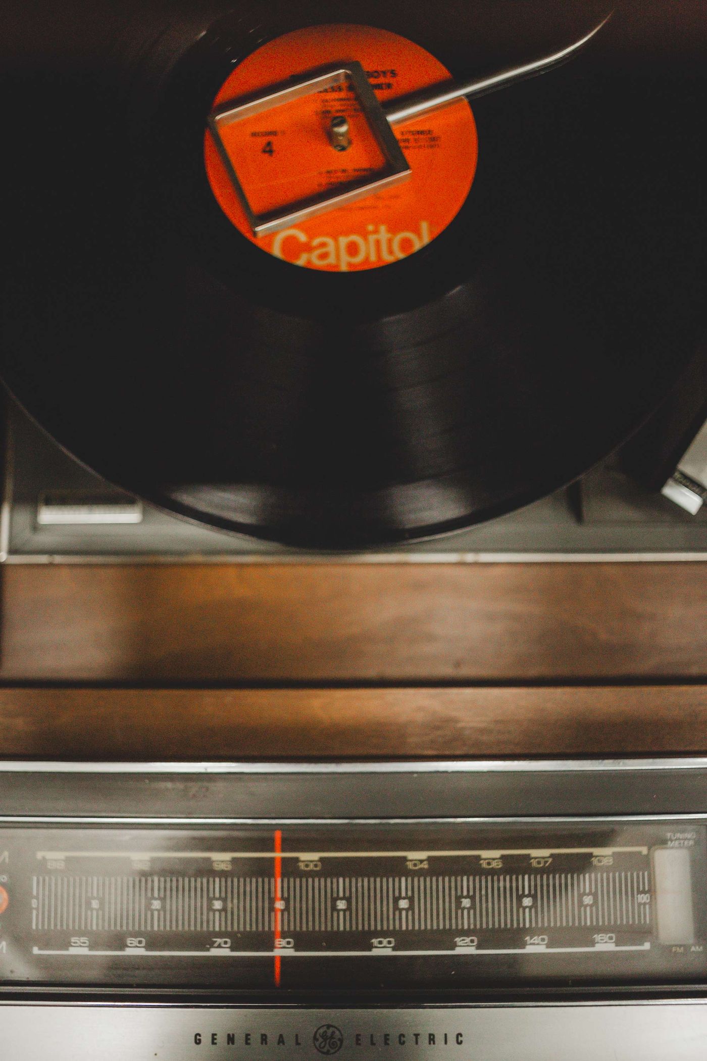 A record turning on a vintage console above the FM and AM radio dial