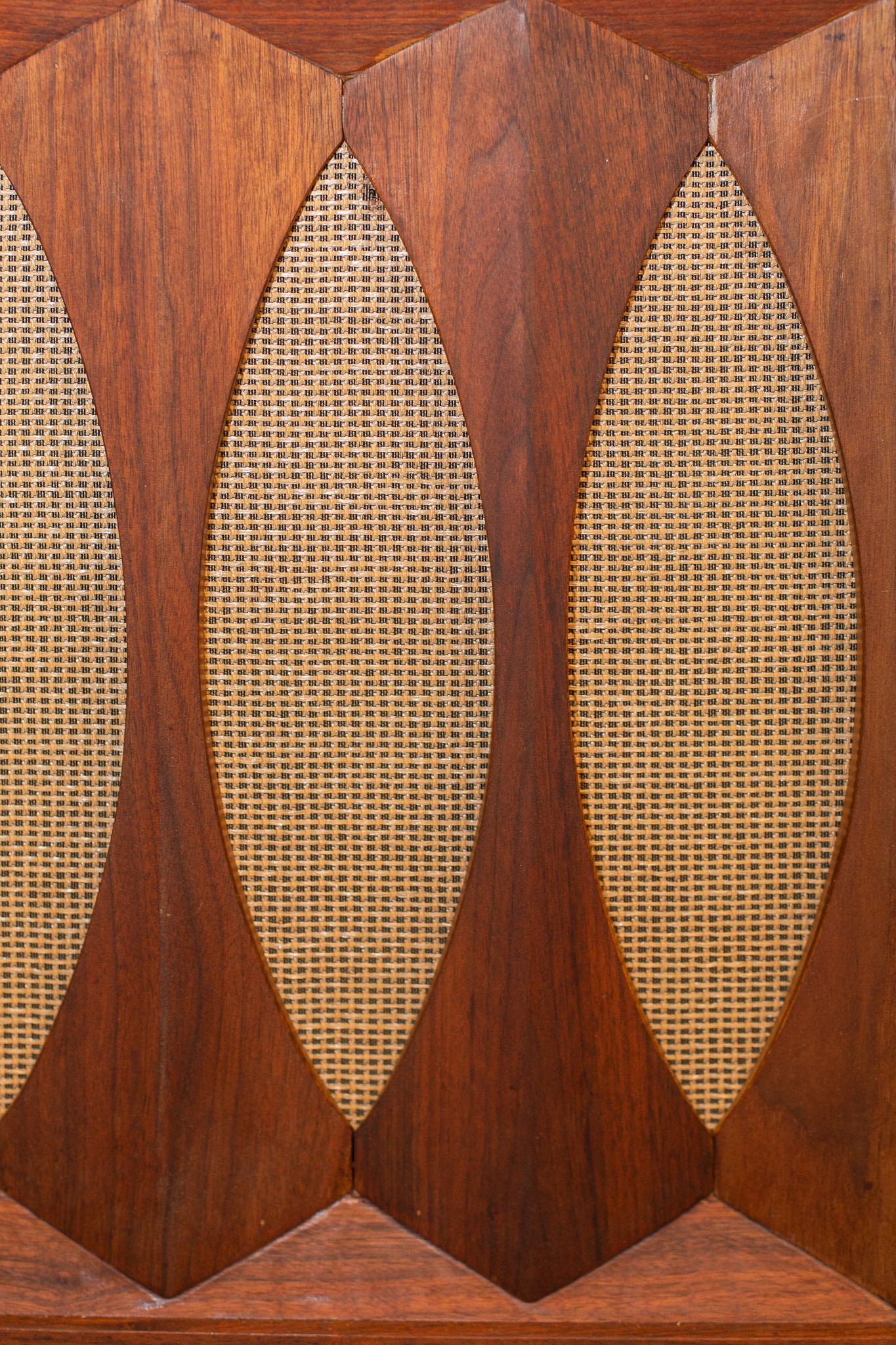 Walnut speaker panel with oval woven grille cloth on a vintage console